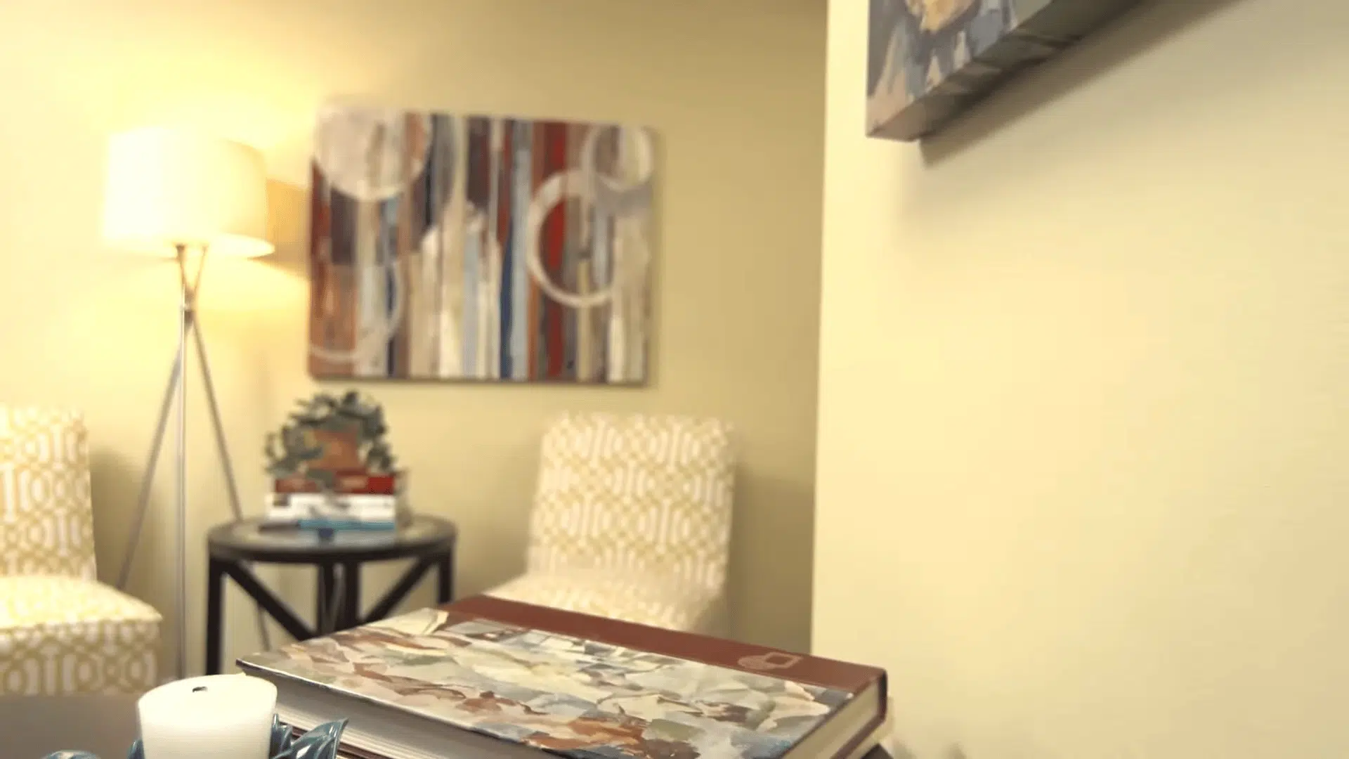A person uses a paint roller to apply a tan-colored coat over a white primed section of a wall. (1)