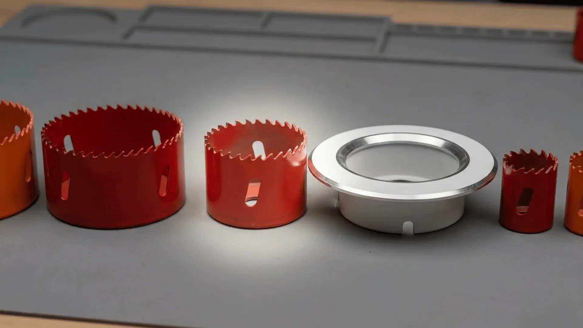 A selection of hole saws with one highlighted to match the size of a recessed light housing.