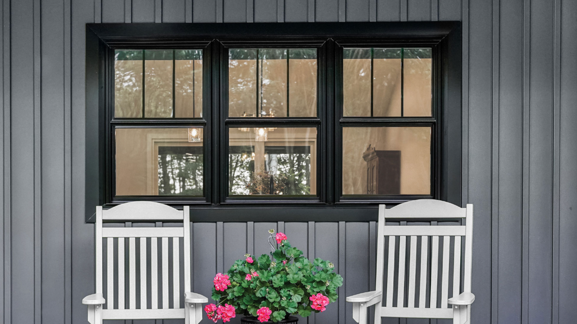 black framed ProVia triple window on dark gray board and batten home exterior showing color customization options with white rocking chairs