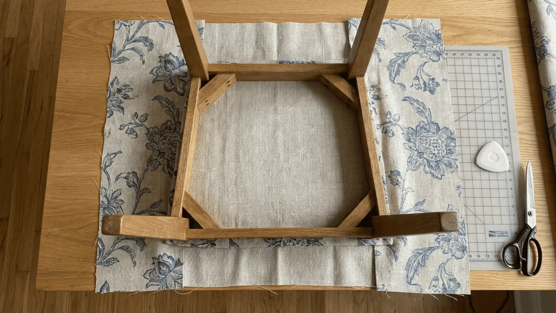 Chair seat placed on fabric with extra material around edges ready for cutting