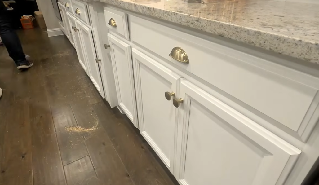 Finished kitchen cabinets with evenly installed handles and pulls, showing clean alignment and consistent placement