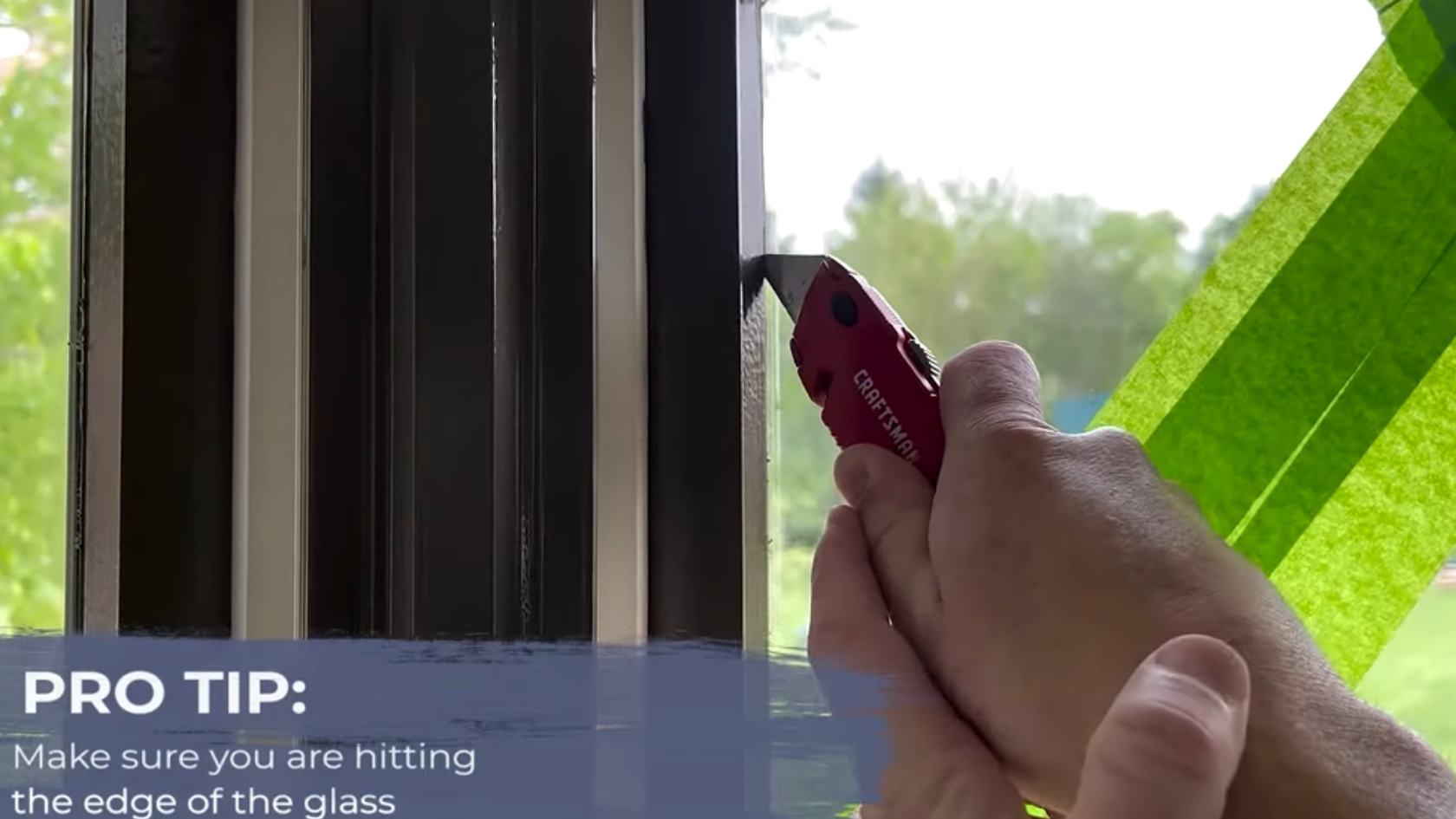 Hand using a utility knife along window glass edge with green tape on cracked pane and repair tip text overlay