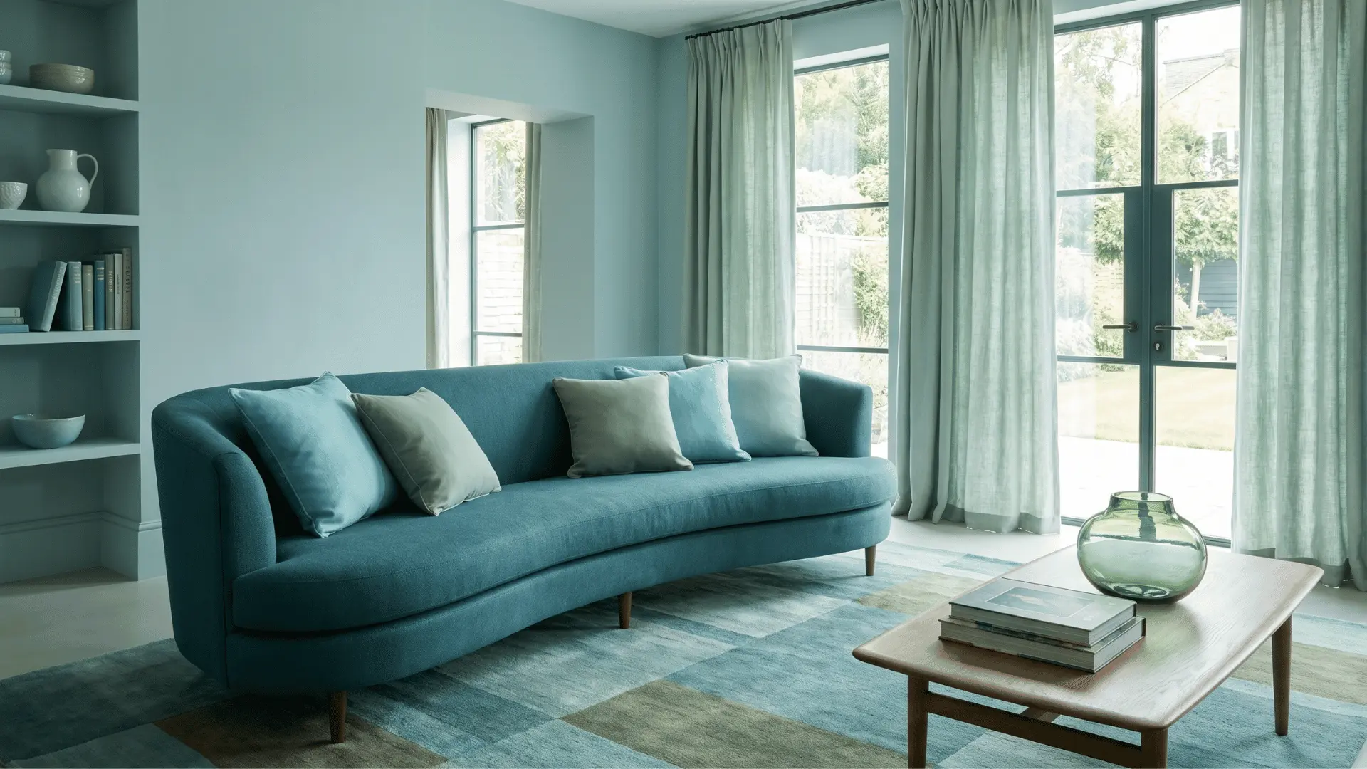 Living room with blue, blue-green, and green colors used across walls, sofa, and decor