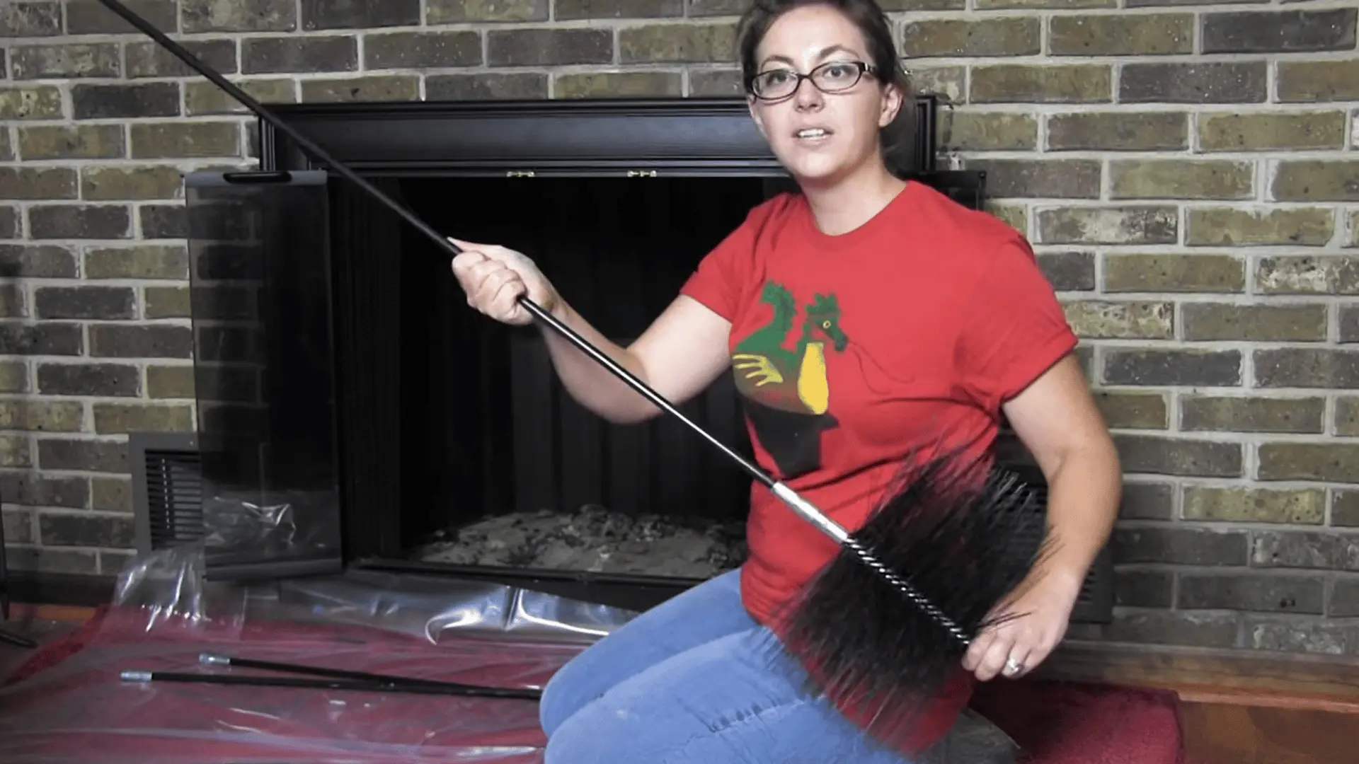 Person attaching chimney brush to rod, preparing tool setup before inserting into fireplace flue