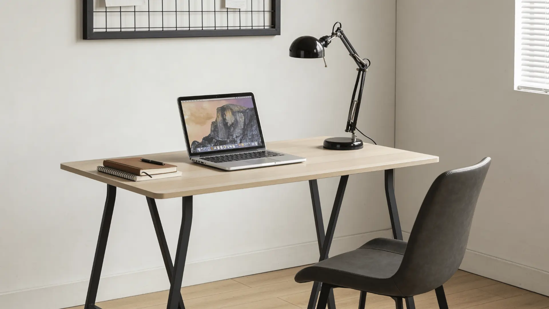 Study table with laptop, notebook, and lamp set up in a home workspace