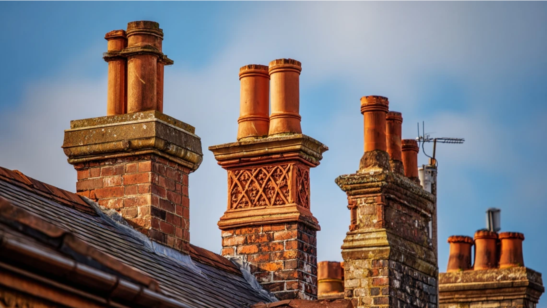 tall Tudor Revival chimney stacks with twisted patterned brickwork shafts and decorative terracotta chimney pots