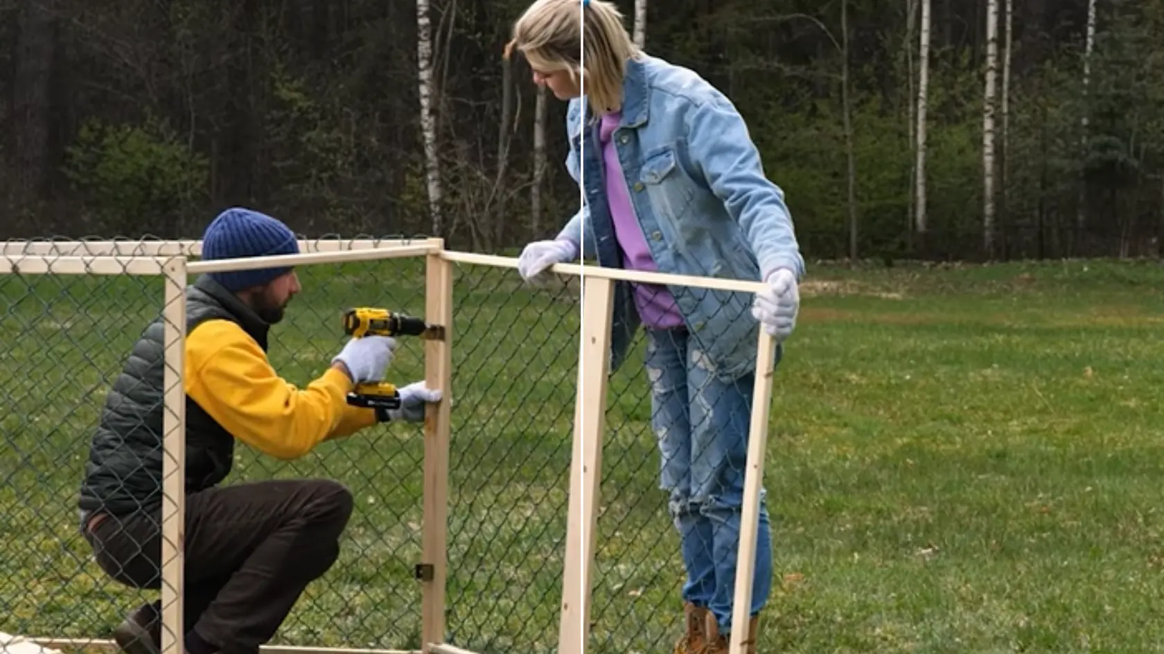 Two people attaching wire mesh to a wooden frame using a drill outdoors on grass