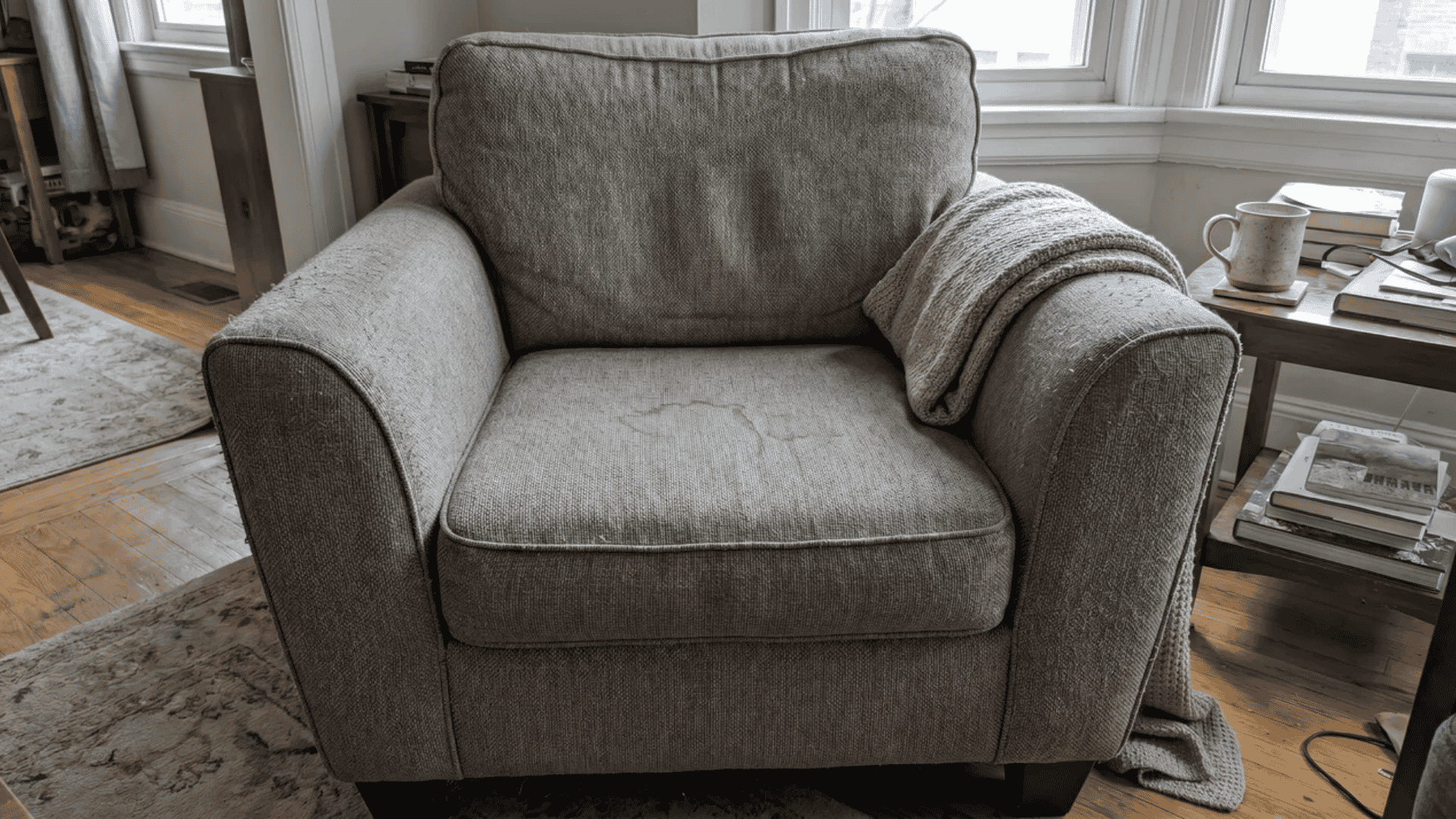 Upholstered chair with light stain and minor surface marks in a home setting