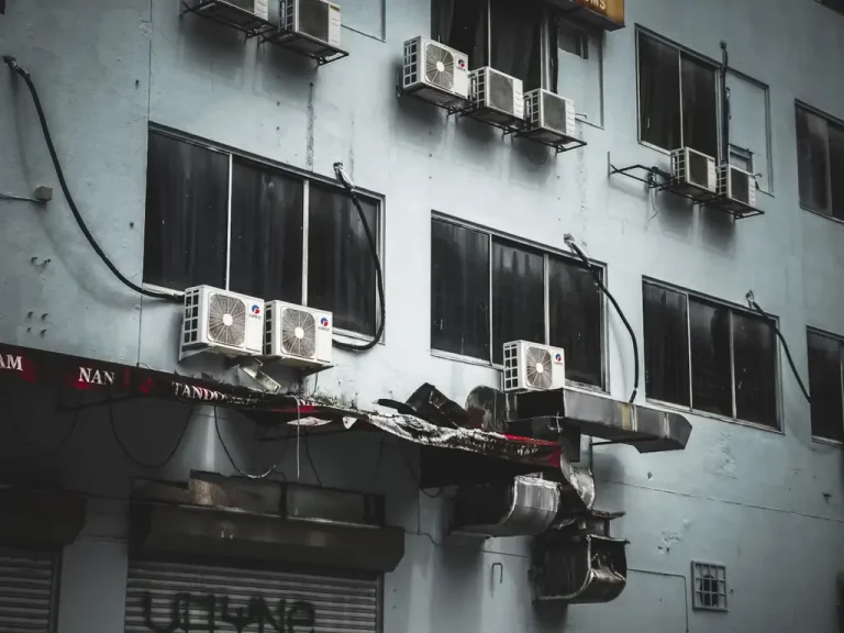 Multiple air conditioning units mounted on the exterior of an urban building