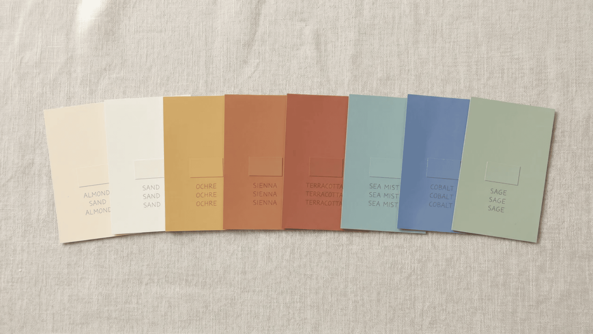 Eight Mediterranean paint cards ranging from almond and sand through ochre, sienna, terracotta, sea mist, cobalt, to sage.