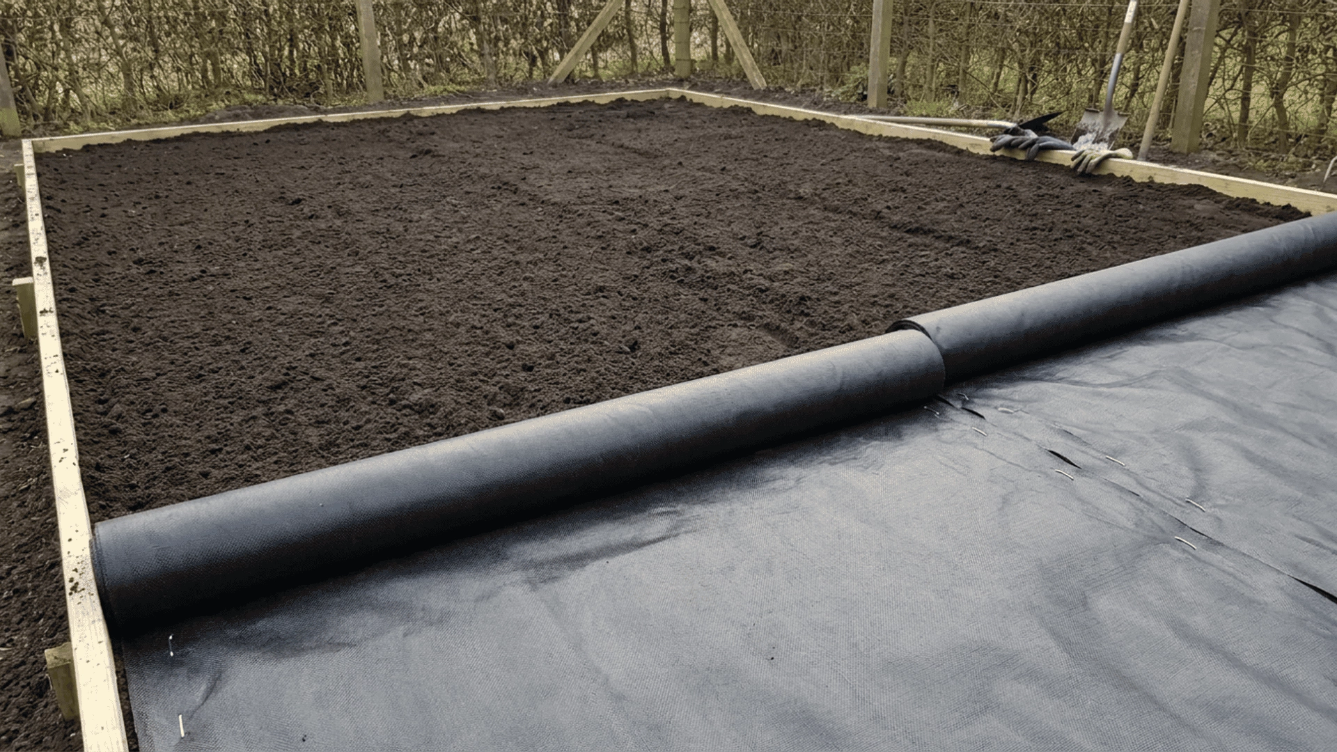 _       A cleared and leveled garden area with a weed barrier or hardware cloth being laid down at the bottom.
