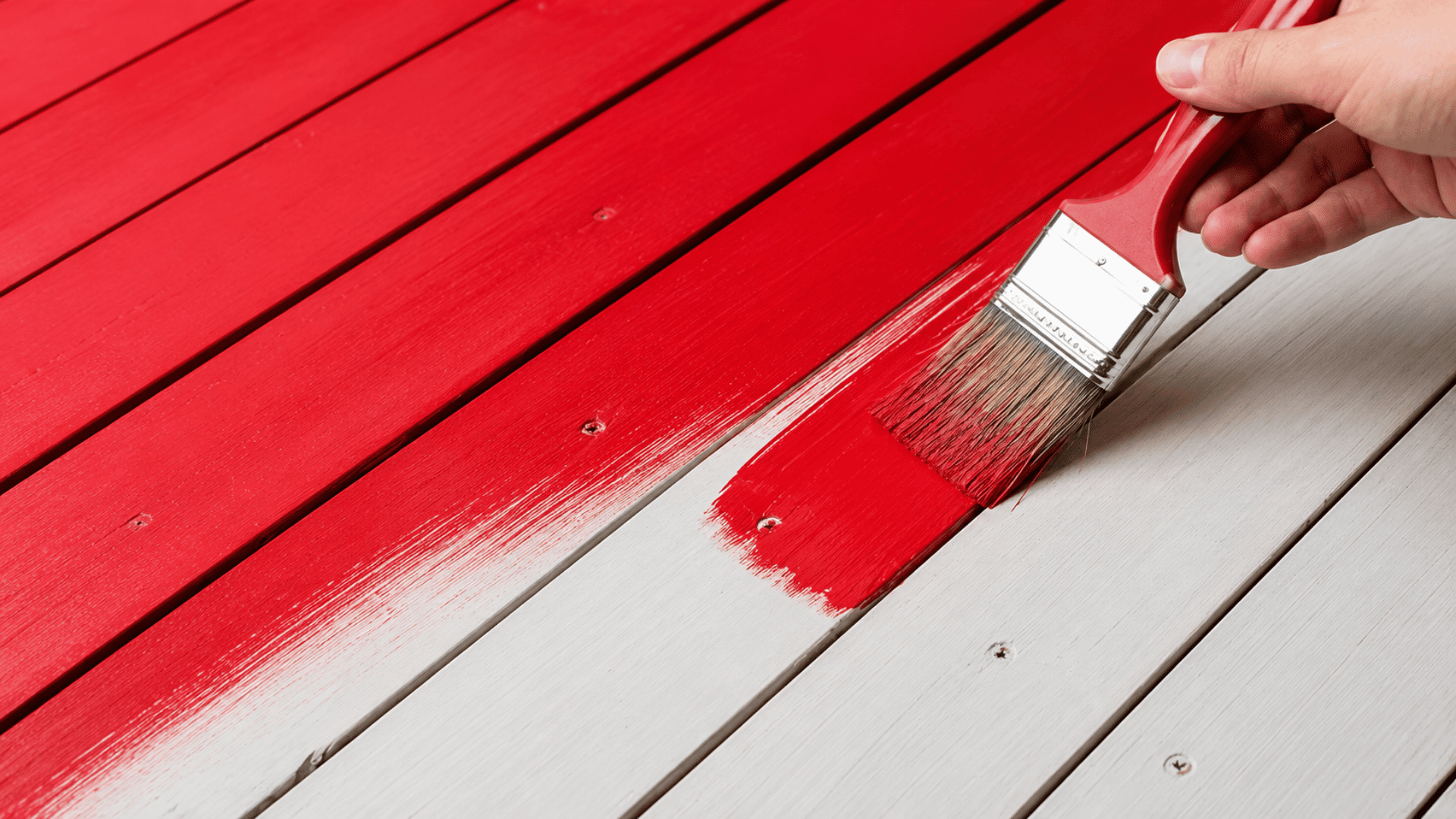 acrylic paint being applied to a wooden board with painting supplies and finished wood projects nearby