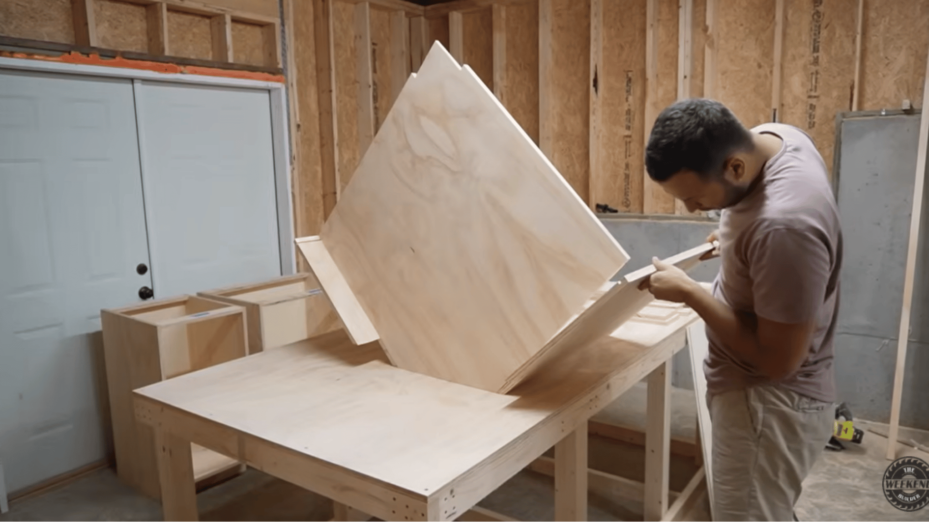 building a corner kitchen cabinet from plywood on a workbench during a custom DIY kitchen cabinet project.