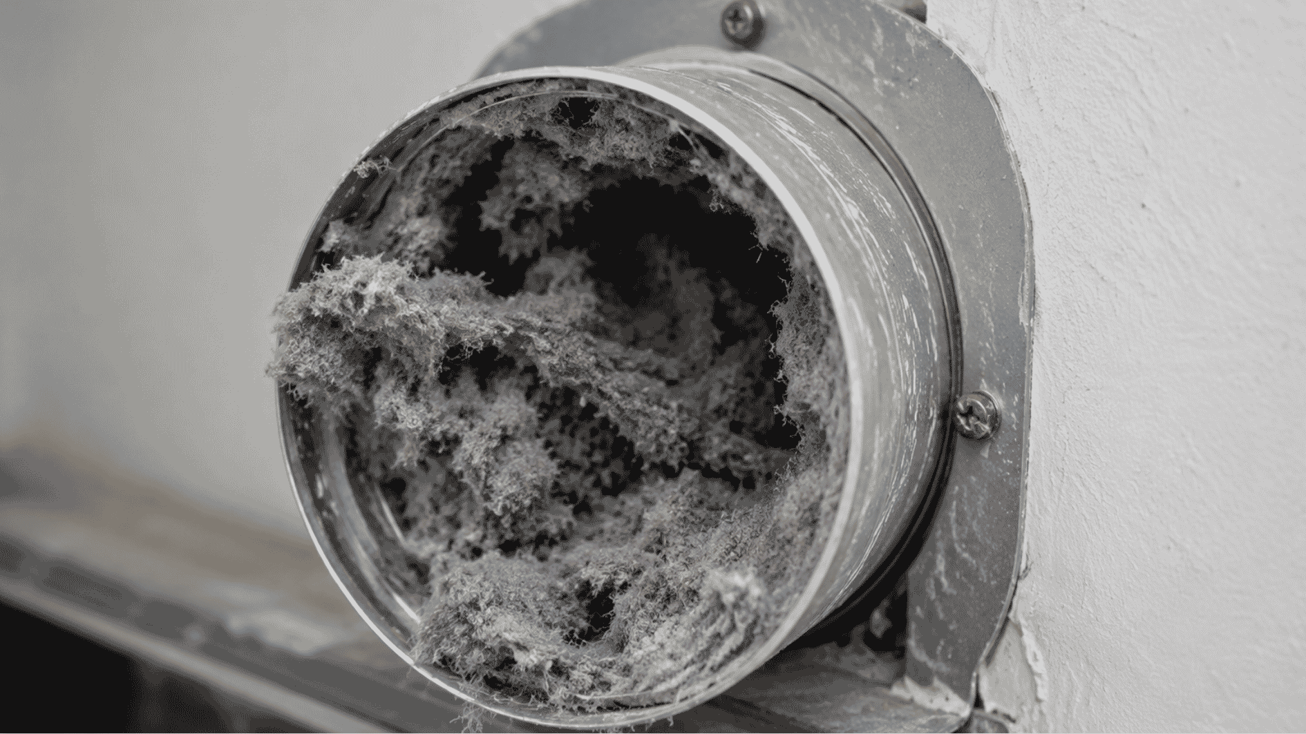 close-up of a clogged dryer vent filled with heavy lint buildup