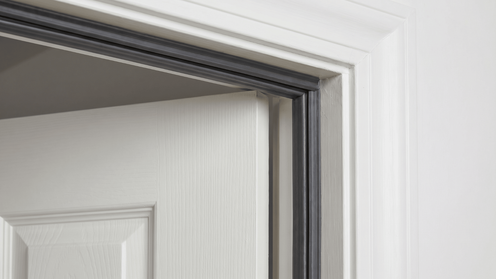Close view of door frame with rubber weatherstripping applied along the top and side edges