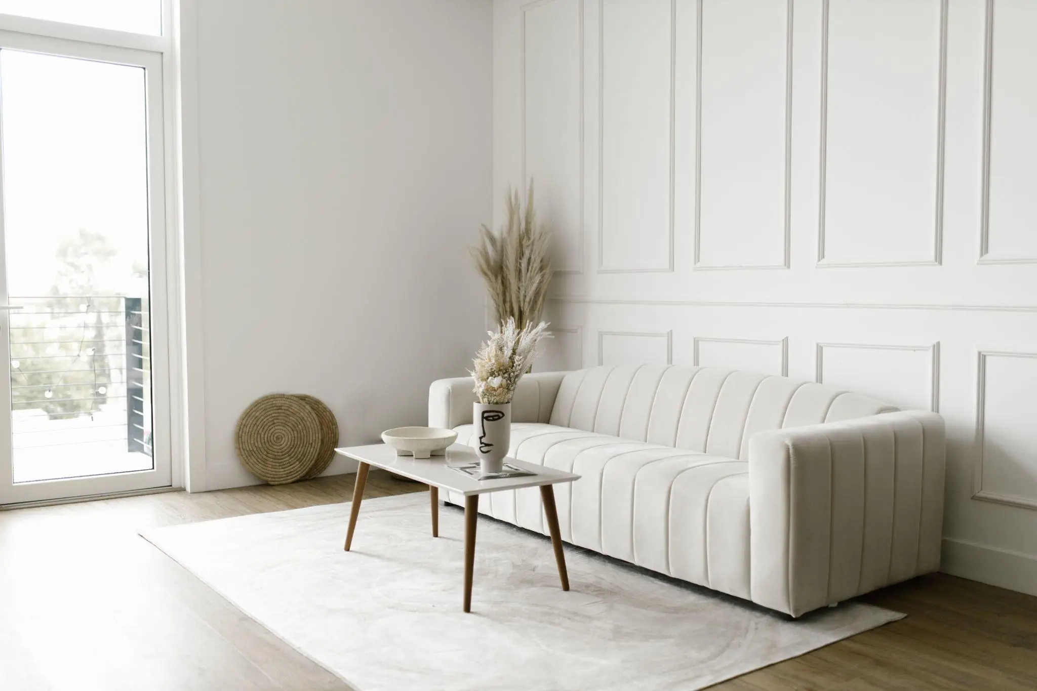 Minimalist living room with white sofa and coffee table in bright natural light