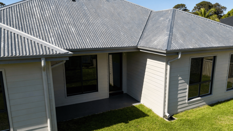 light gray metal roof on a modern home with white siding and green lawn