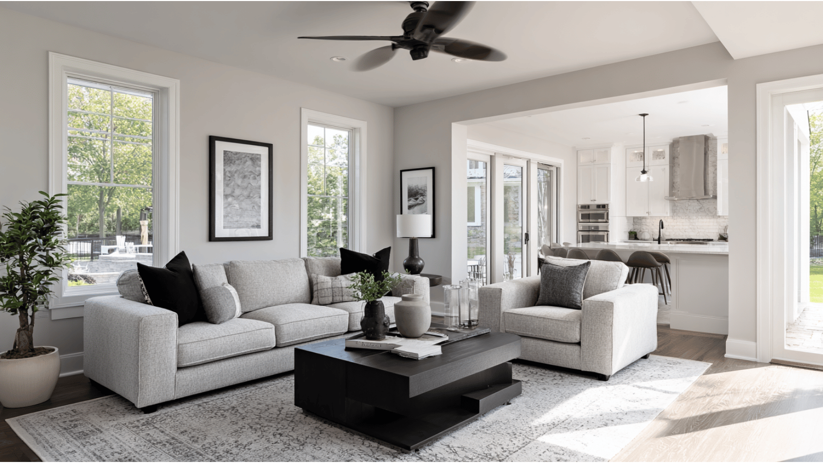 Living room with Agreeable Gray walls, gray furniture, white trim, and modern neutral decor