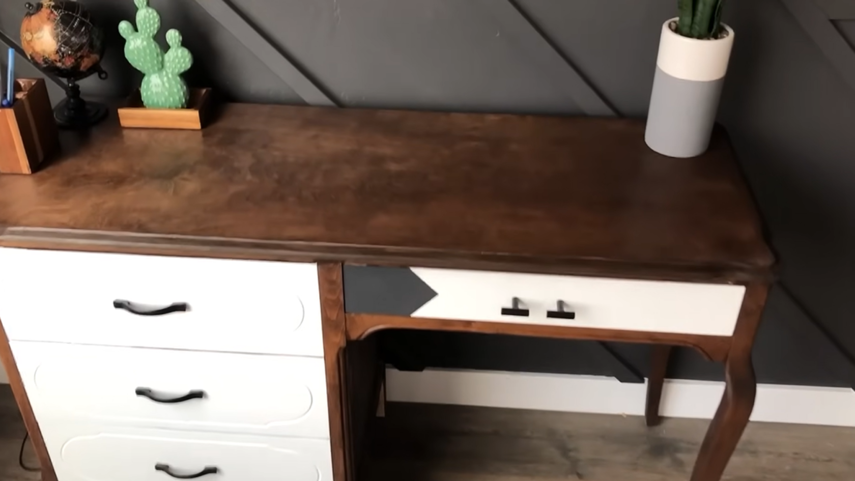 Refinished wooden desk with dark stained top, white drawers, and decorative items on surface