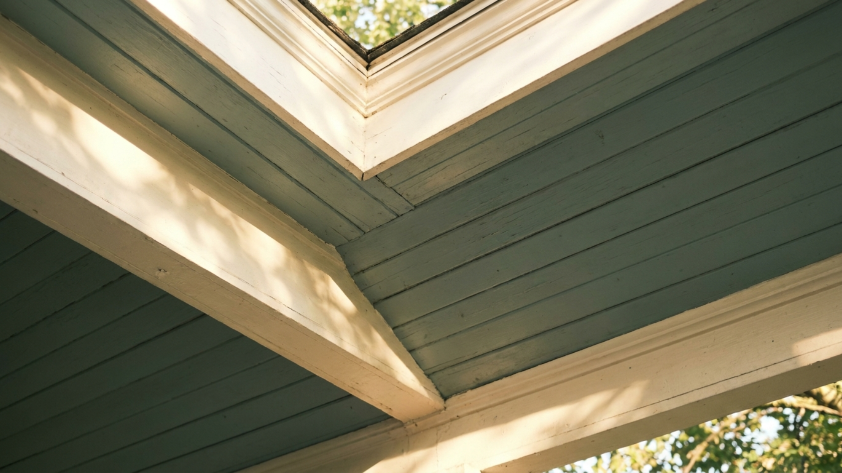 Soft blue-green porch ceiling with cream trim visible along the edge in warm natural light.