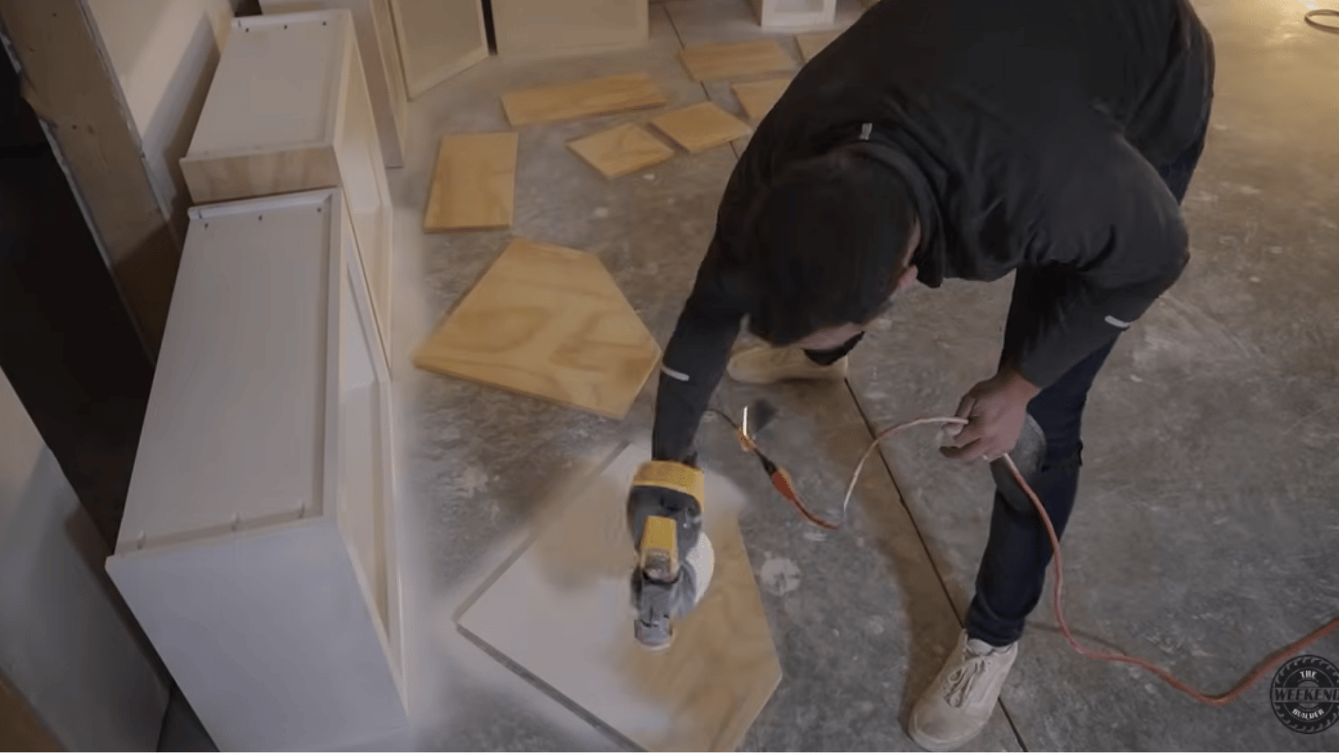 spraying primer or paint onto cabinet door panels during the finishing stage of a DIY kitchen cabinet project.
