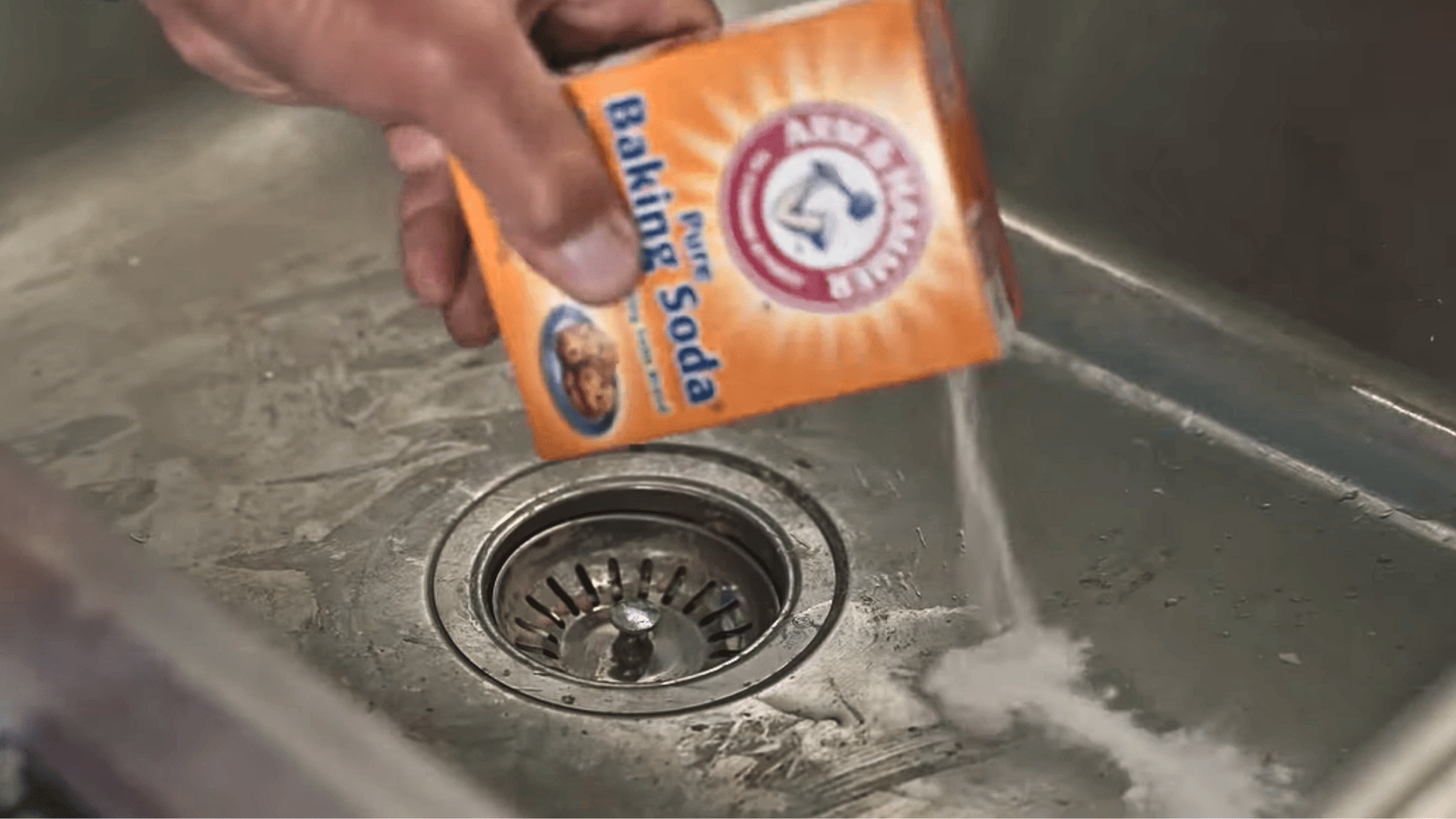 sprinkling baking soda into a stainless steel sink to remove stains and buildup