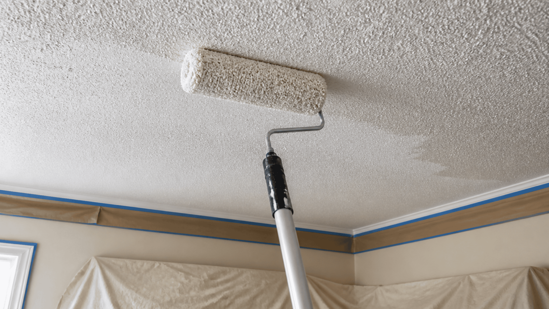 Thick nap roller applying paint lightly to a popcorn ceiling.