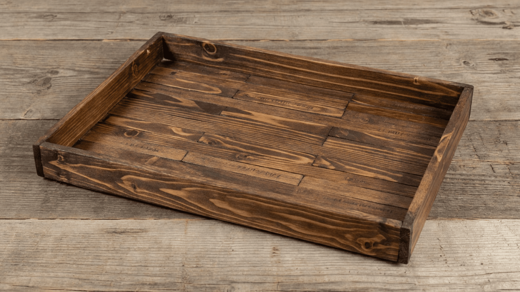 Tray made from stained paint stir sticks with raised wooden edges on a table