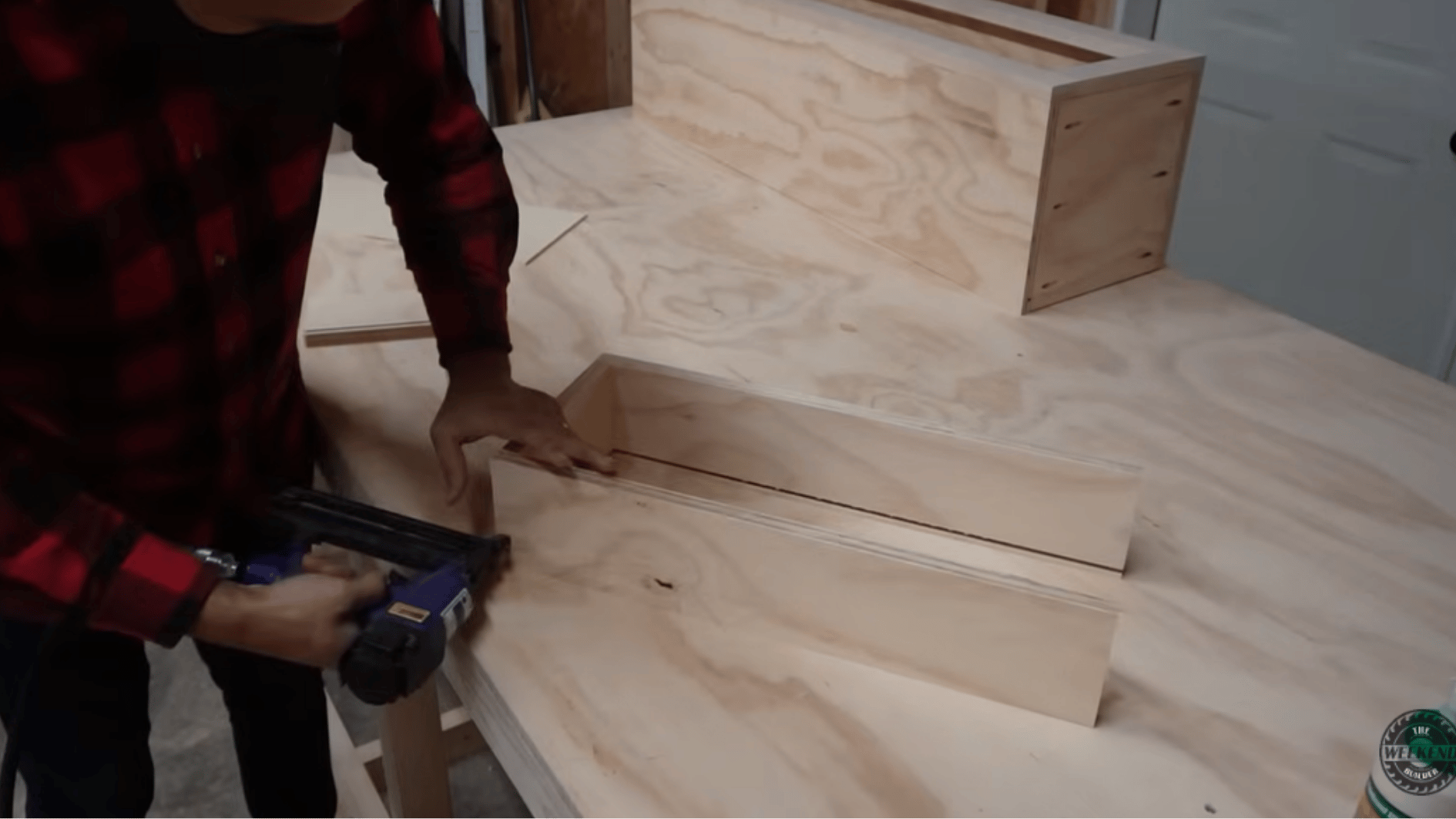 using a brad nailer to assemble cabinet components during the construction of custom DIY kitchen cabinets.