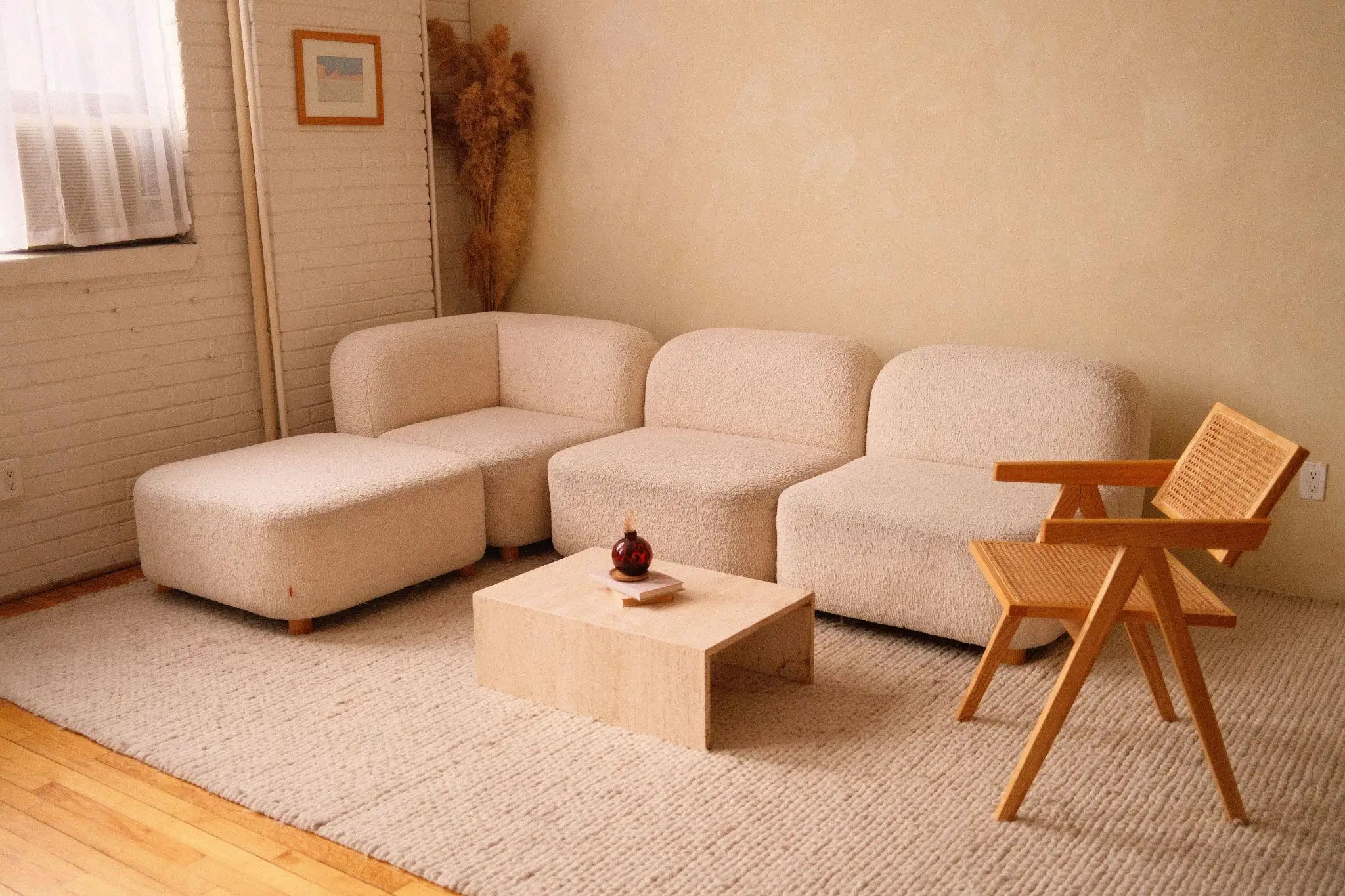 Beige modular sofa and wooden chair in cozy living room with natural light