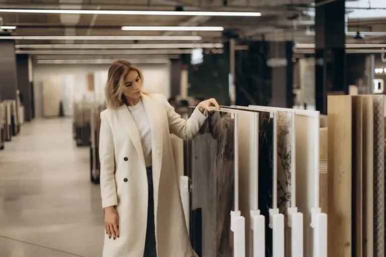 Woman examining countertop samples in modern showroom under bright industrial lighting