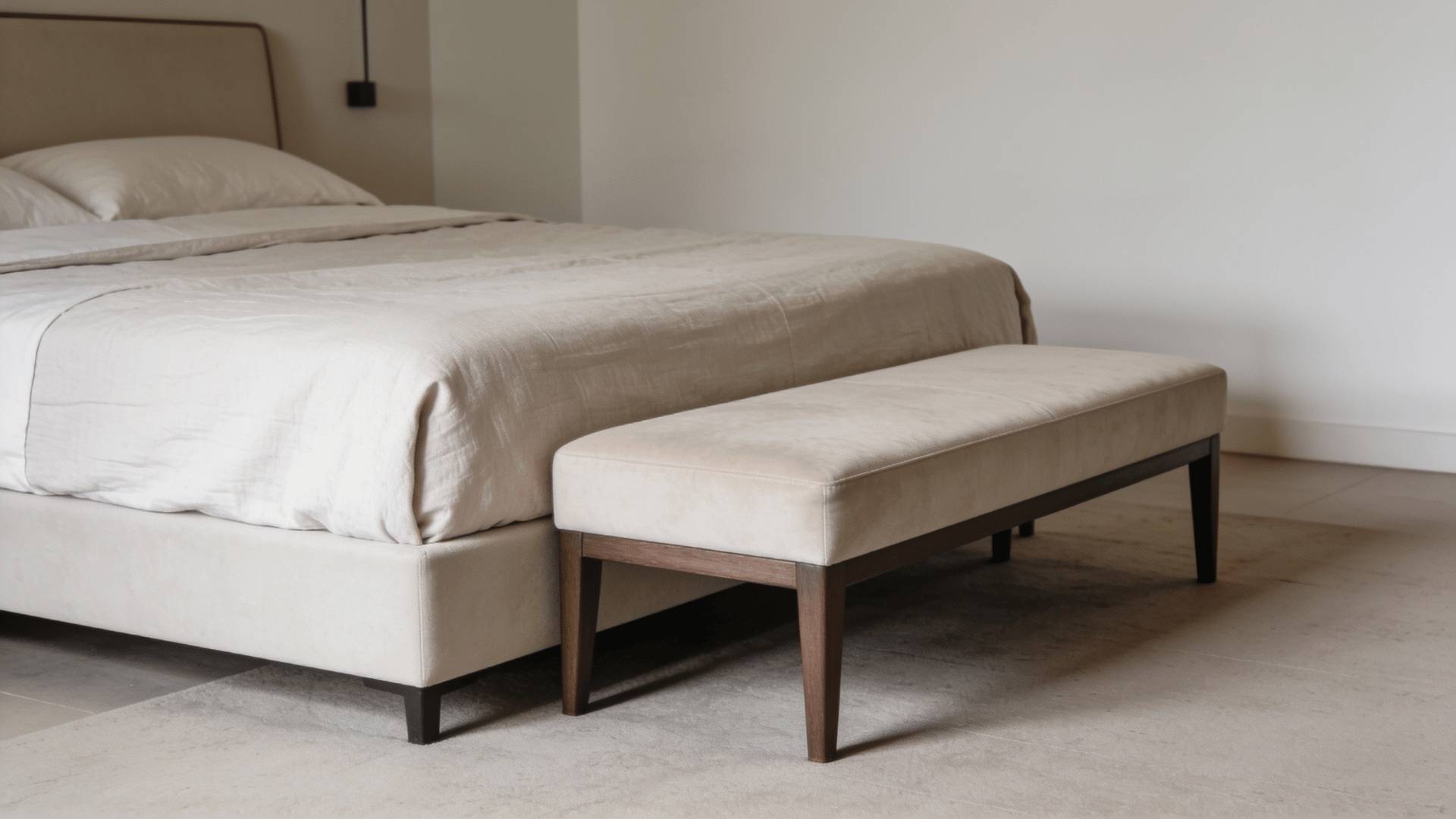 Single bench at the foot of a bed in a minimalist bedroom
