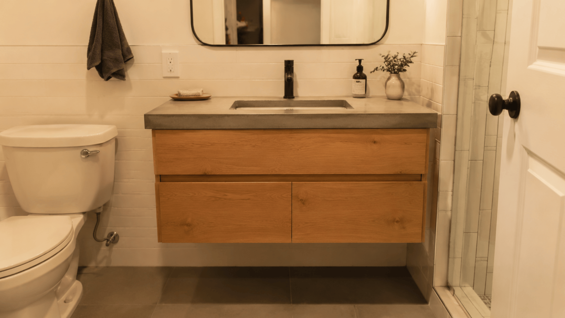 a diy wooden support concrete overlay top bathroom vanity in a simple bathroom setup indoor yellow bulb lighting
