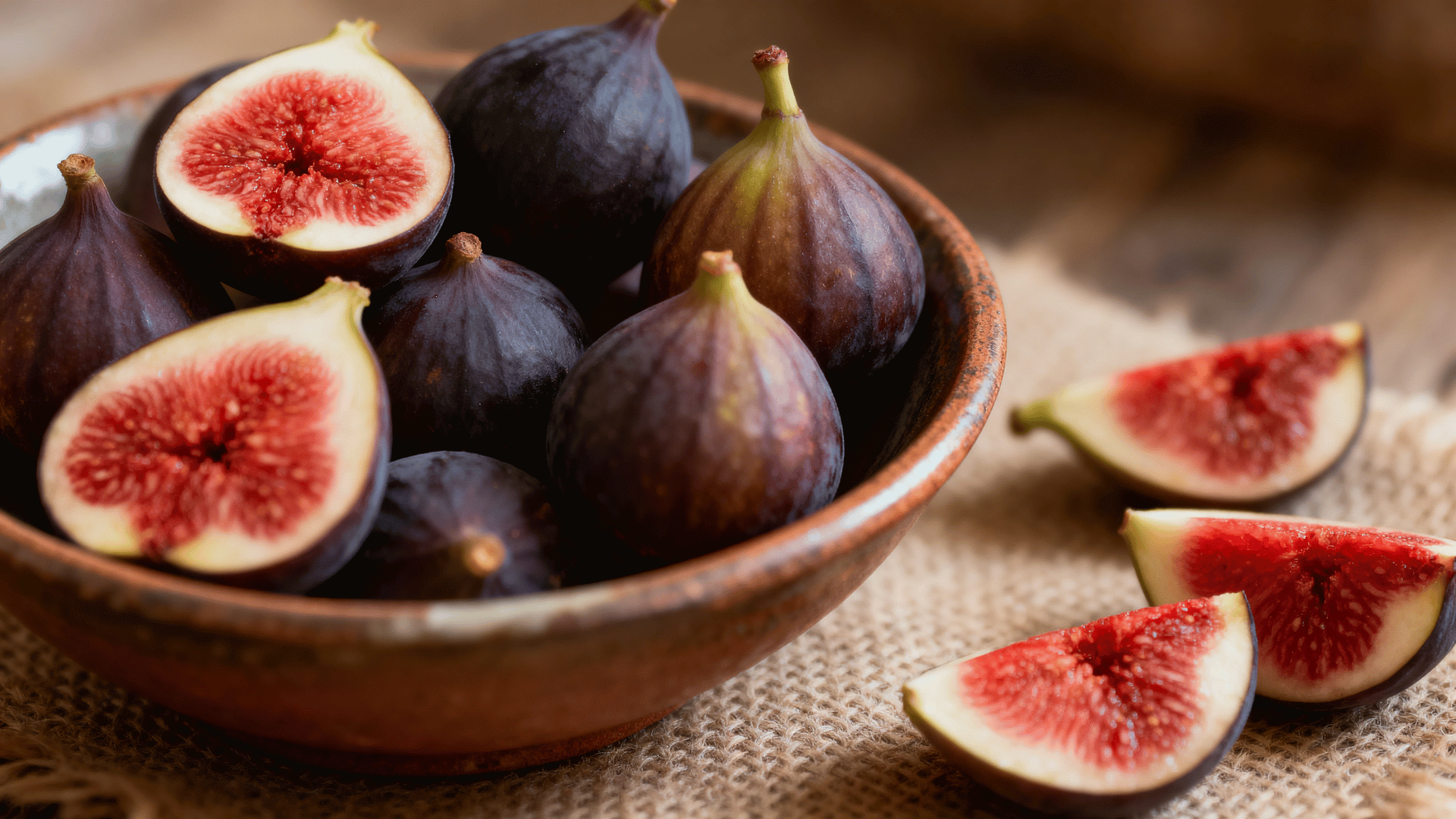 celeste figs small dark purple skin in bowl sliced showing red interior soft lighting