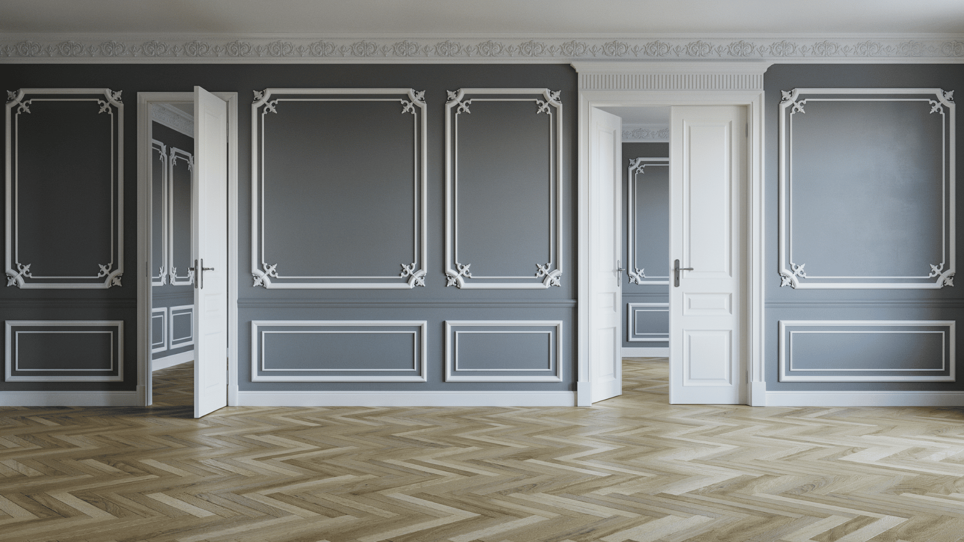 Empty gray room with elegant white wall molding, wainscoting, light herringbone wood floors, and open double interior doors.