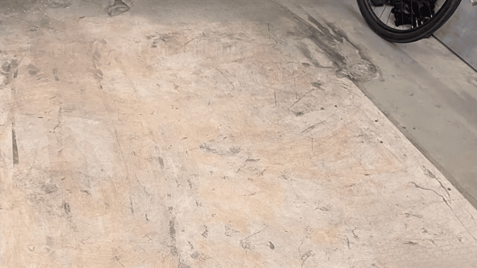Cleaned concrete floor after paint removal with remaining surface marks and texture
