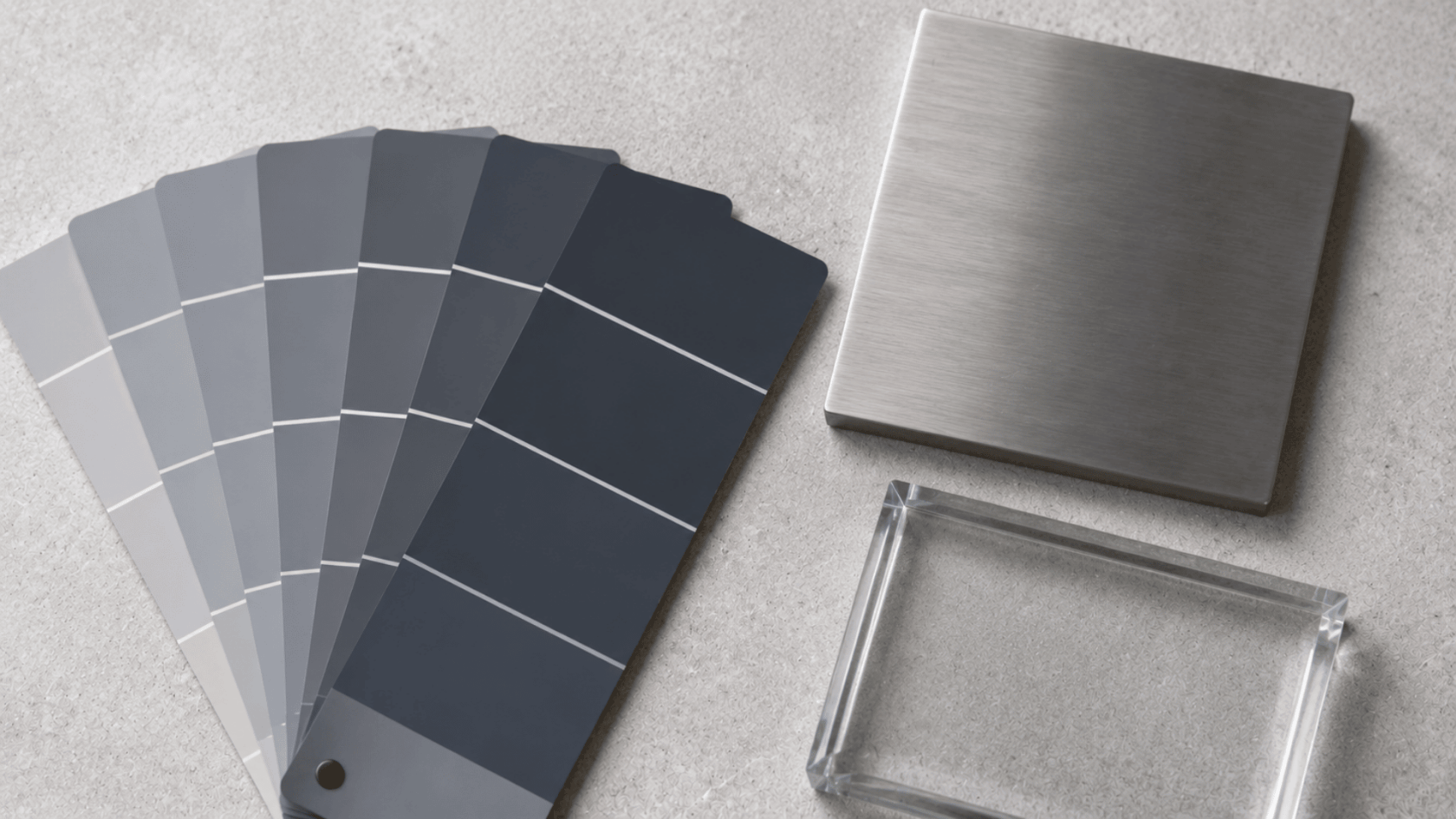 Cool blue-gray paint swatches with a brushed metal sample and clear surface on a neutral background