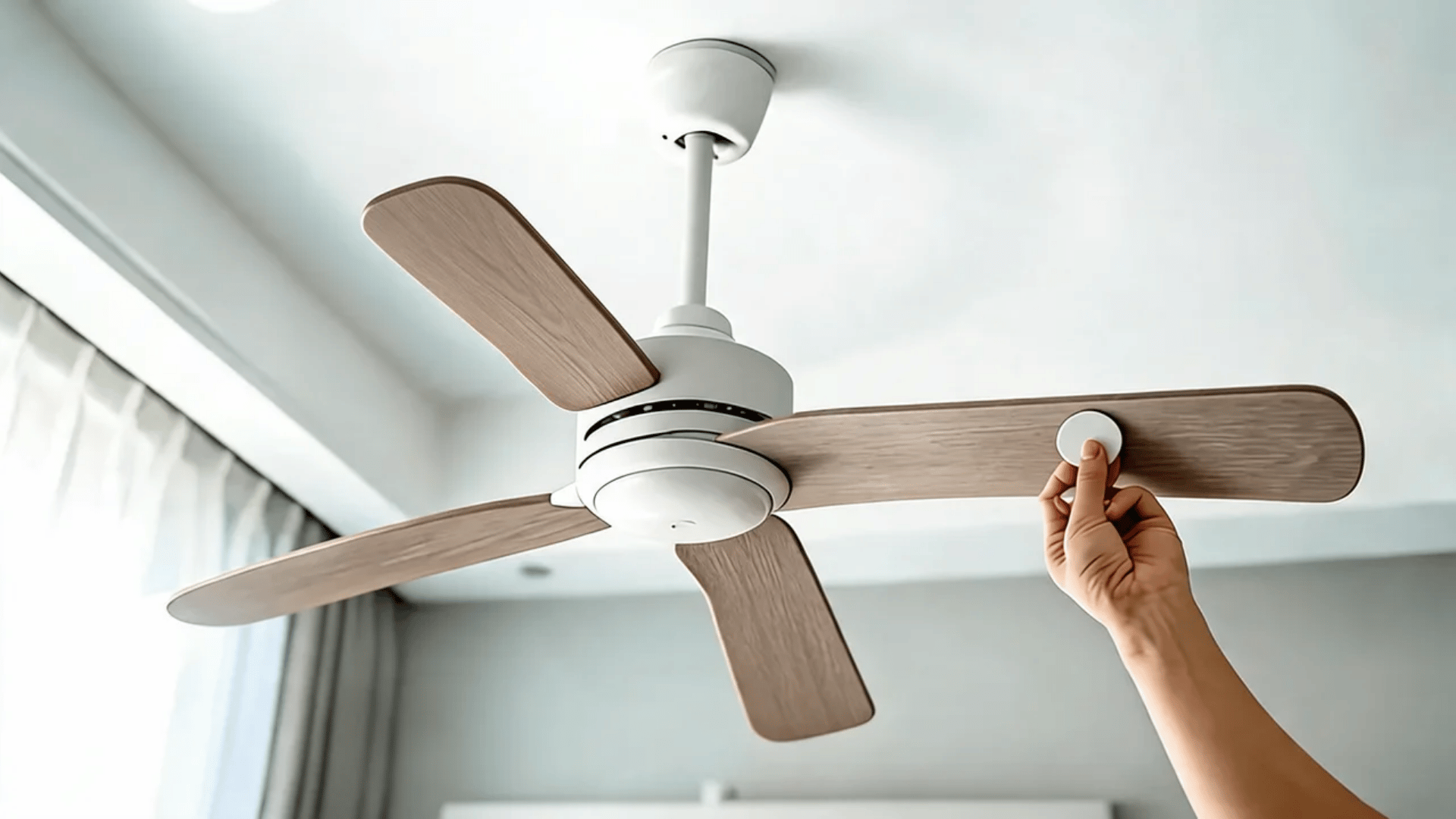 Hand attaching adhesive weight to ceiling fan blade
