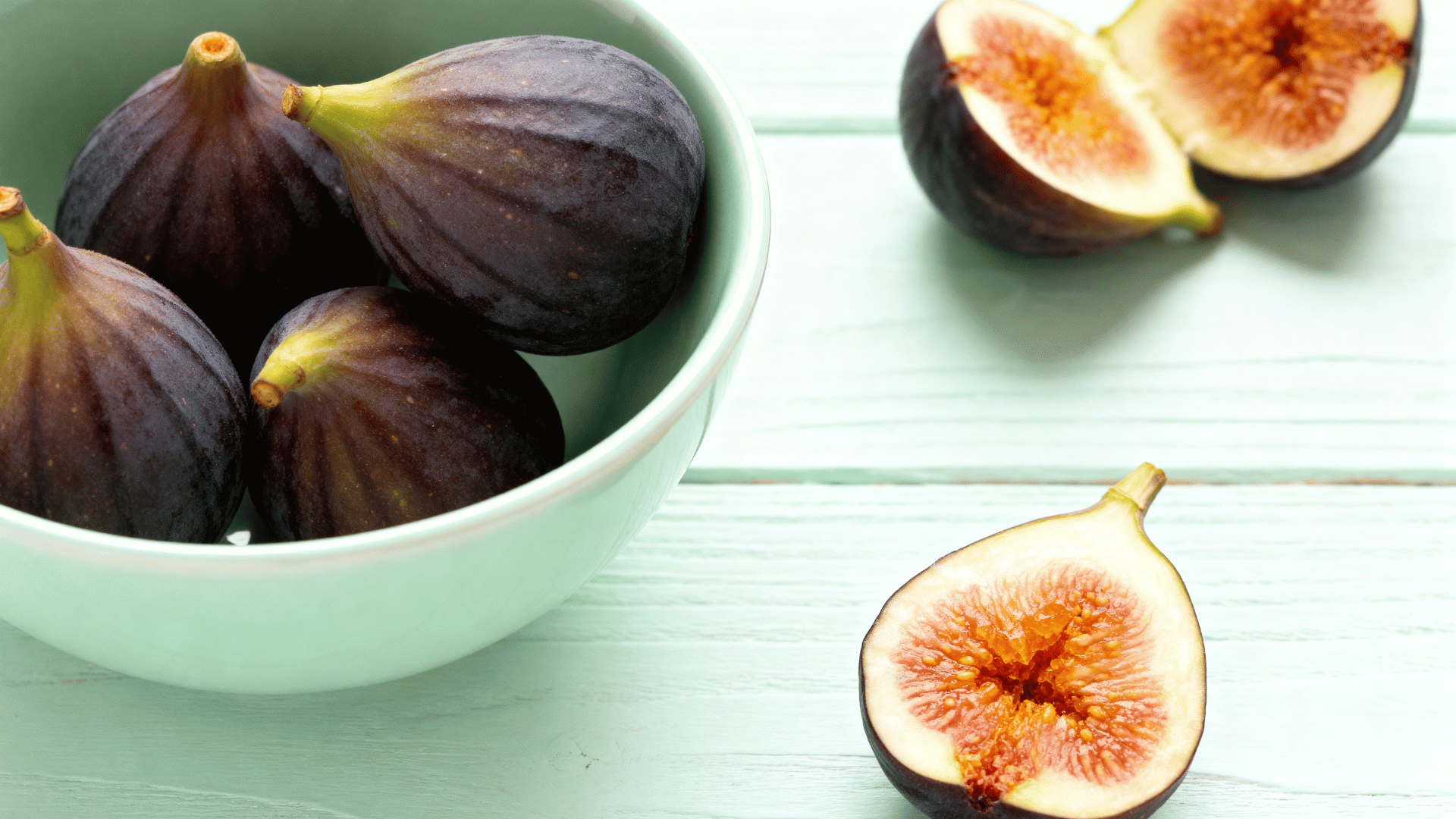 kadota figs in bowl pale green skin sliced showing amber flesh soft bright lighting