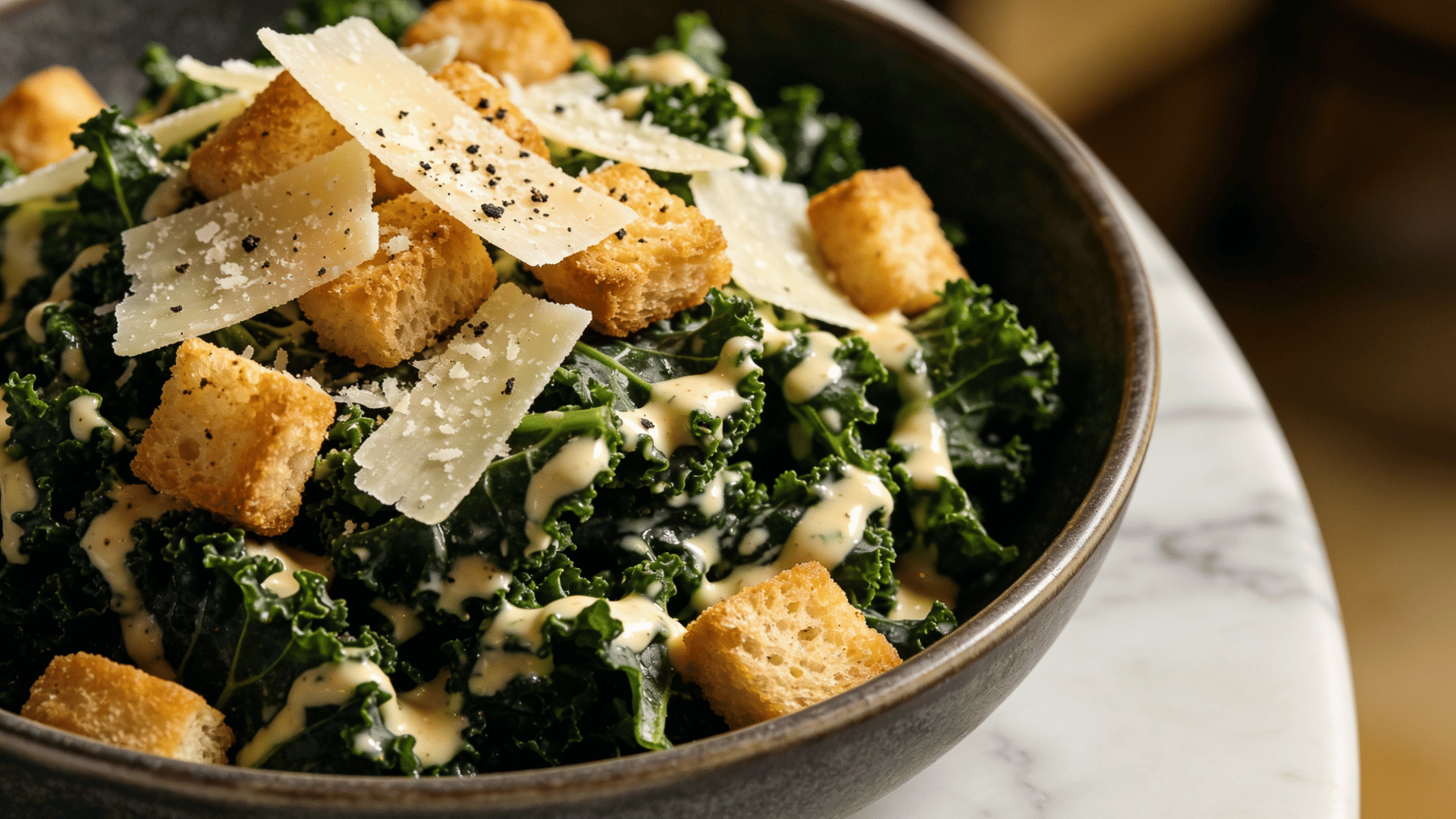 kale caesar salad topped with parmesan cheese, crunchy croutons, and creamy caesar dressing served in a rustic bowl