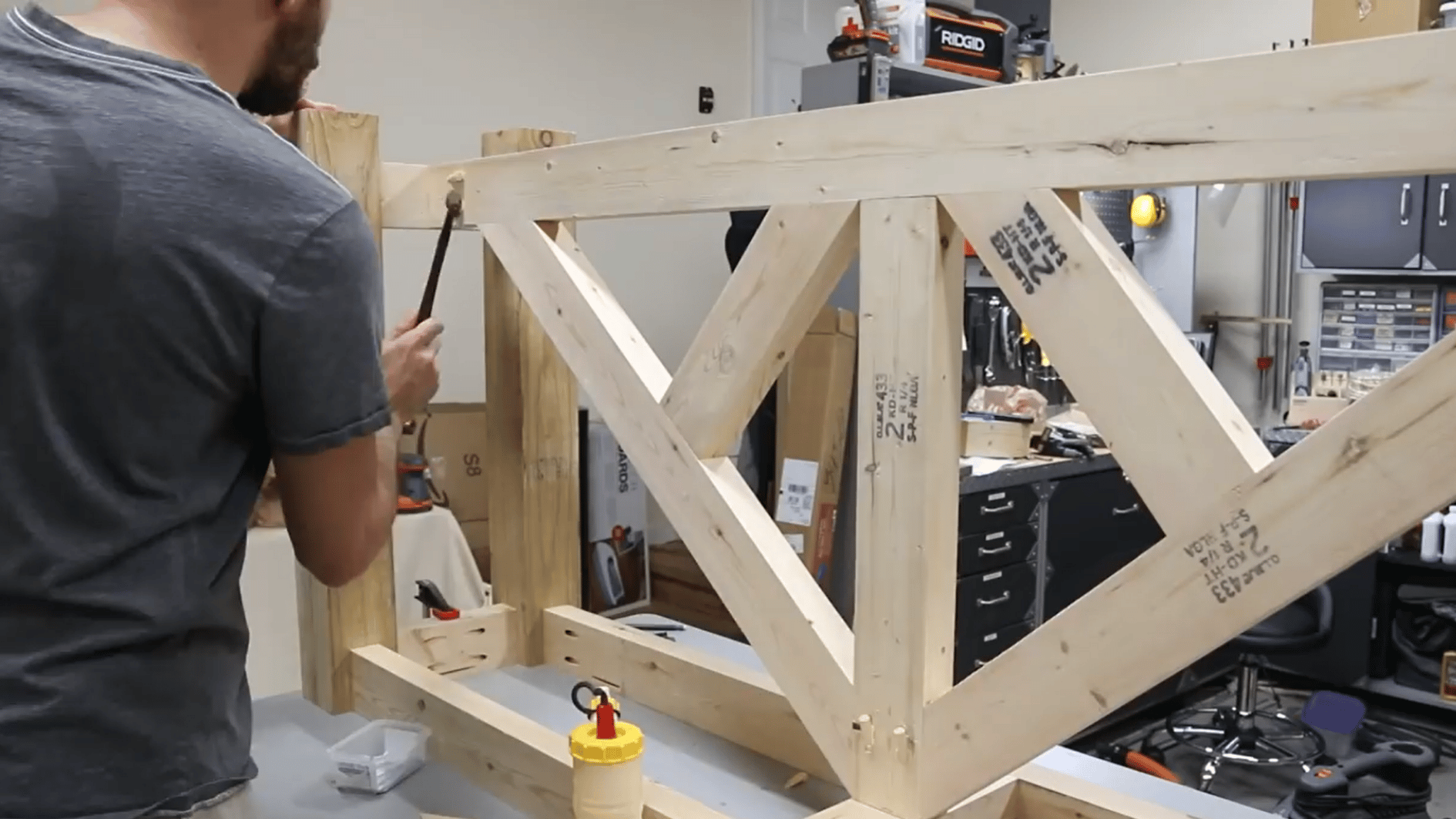 man checking the assembled wooden table frame and angled supports before attaching the wood tabletop