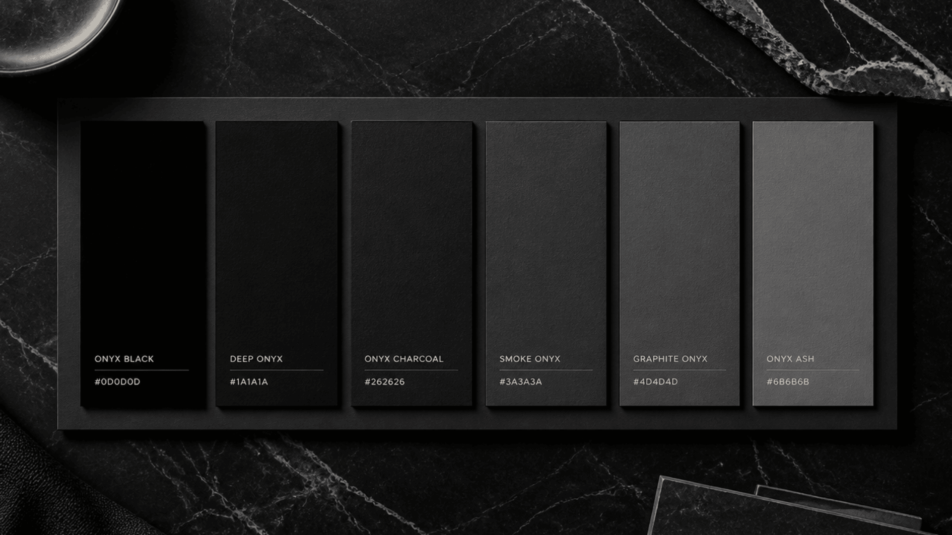 onyx color palette guide showing black and charcoal shade swatches with hex codes on a dark marble background