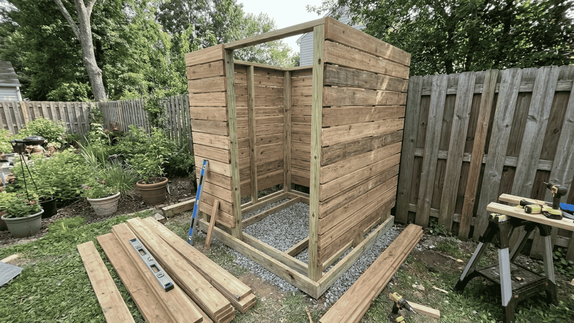 A wooden structure taking shape during a DIY outdoor shower installation