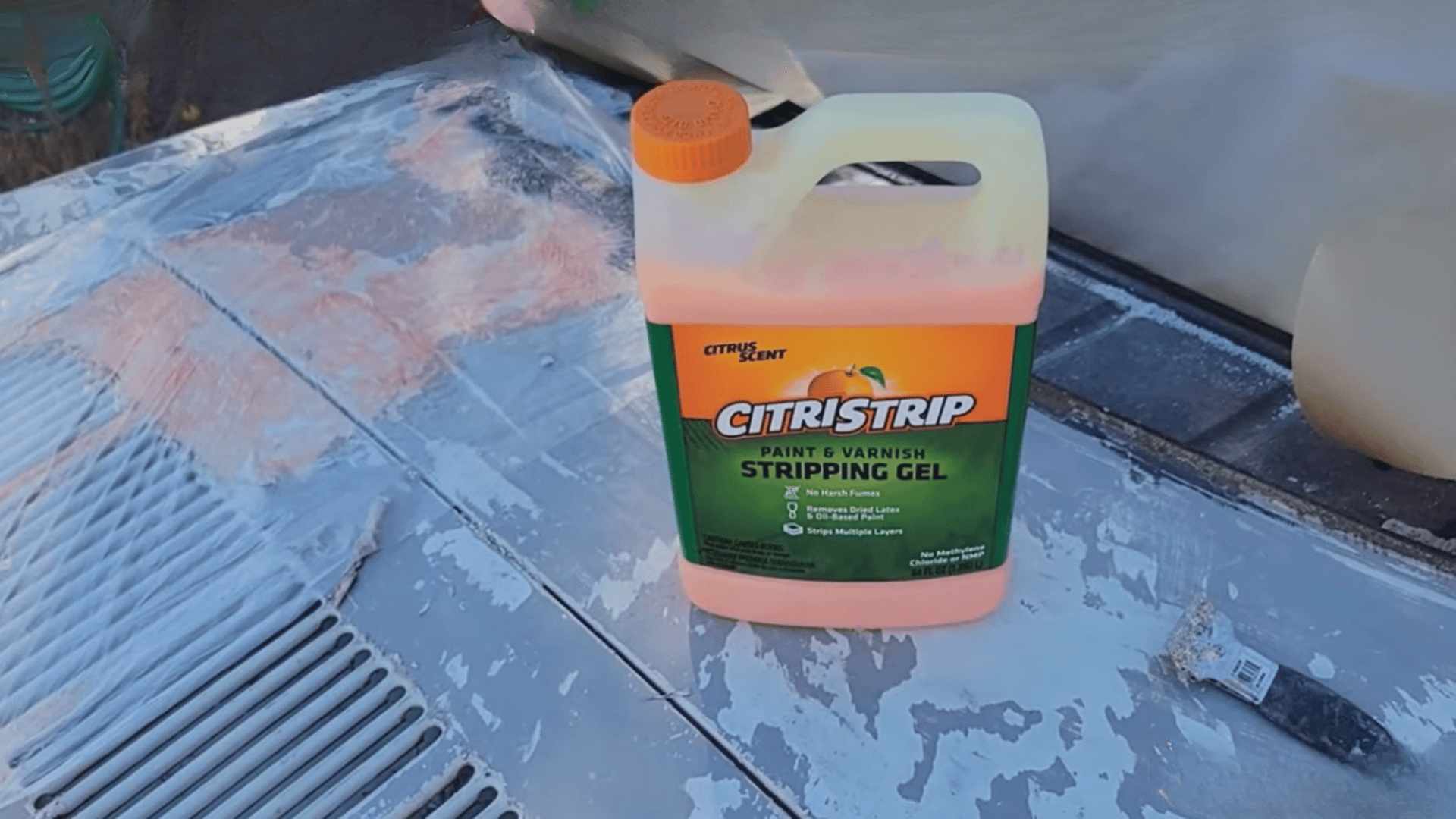 Paint stripping gel container placed on concrete surface during paint removal process