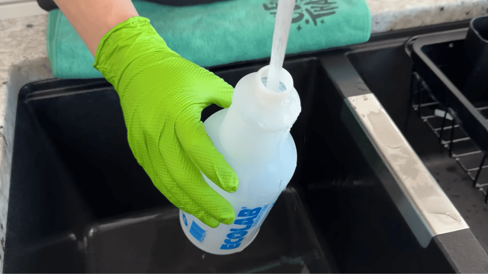 person filling a cleaning spray bottle over a sink with gloves