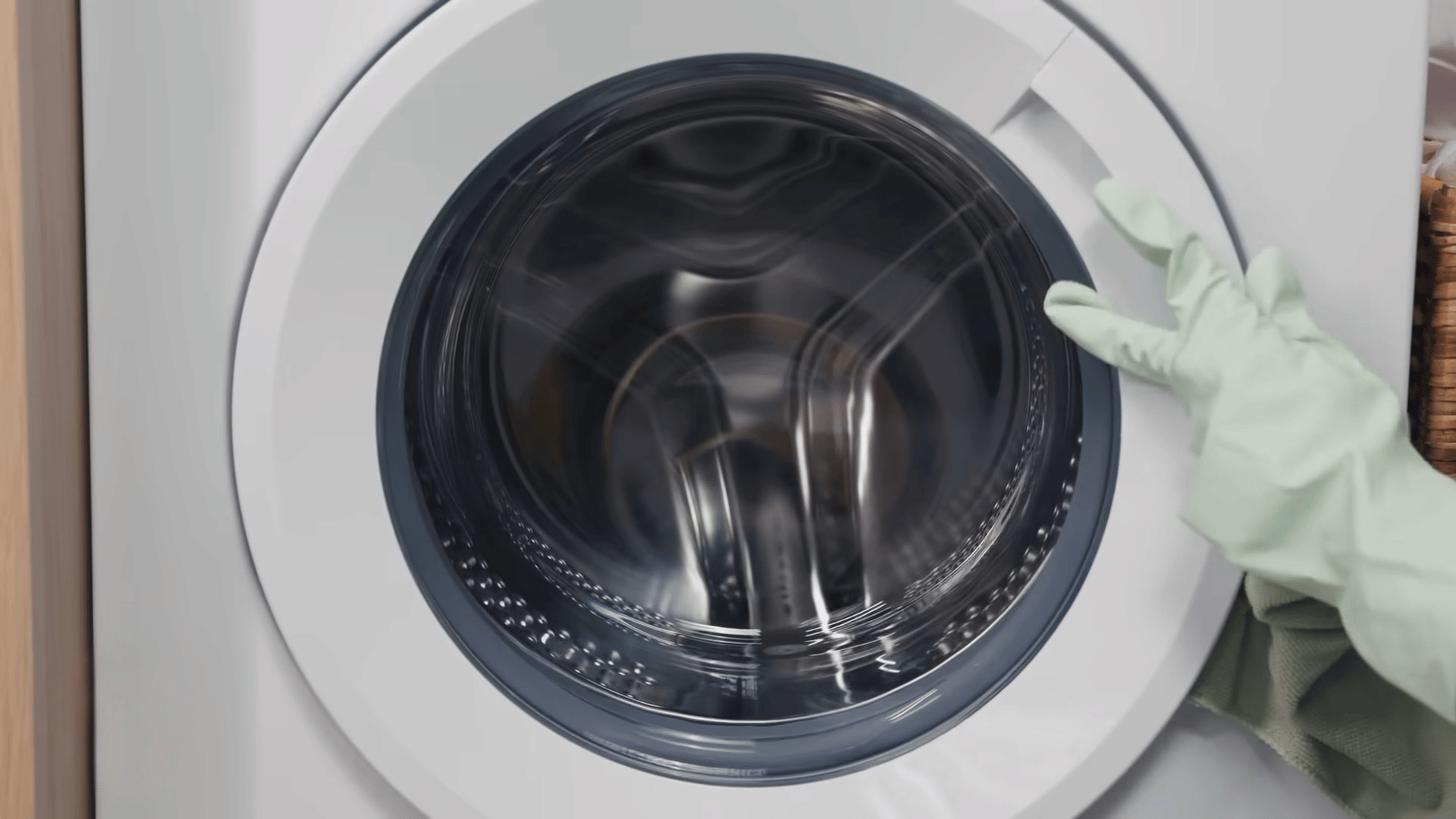 Person pointing to a front-load washing machine door