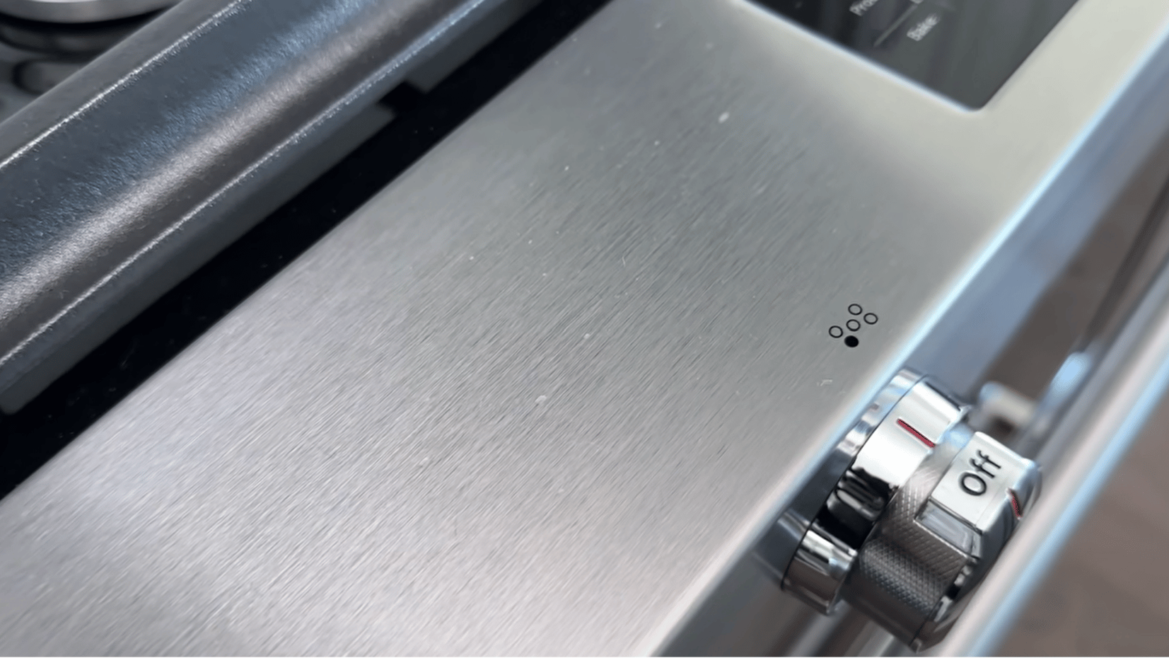 stainless steel oven surface with scratches and control knod