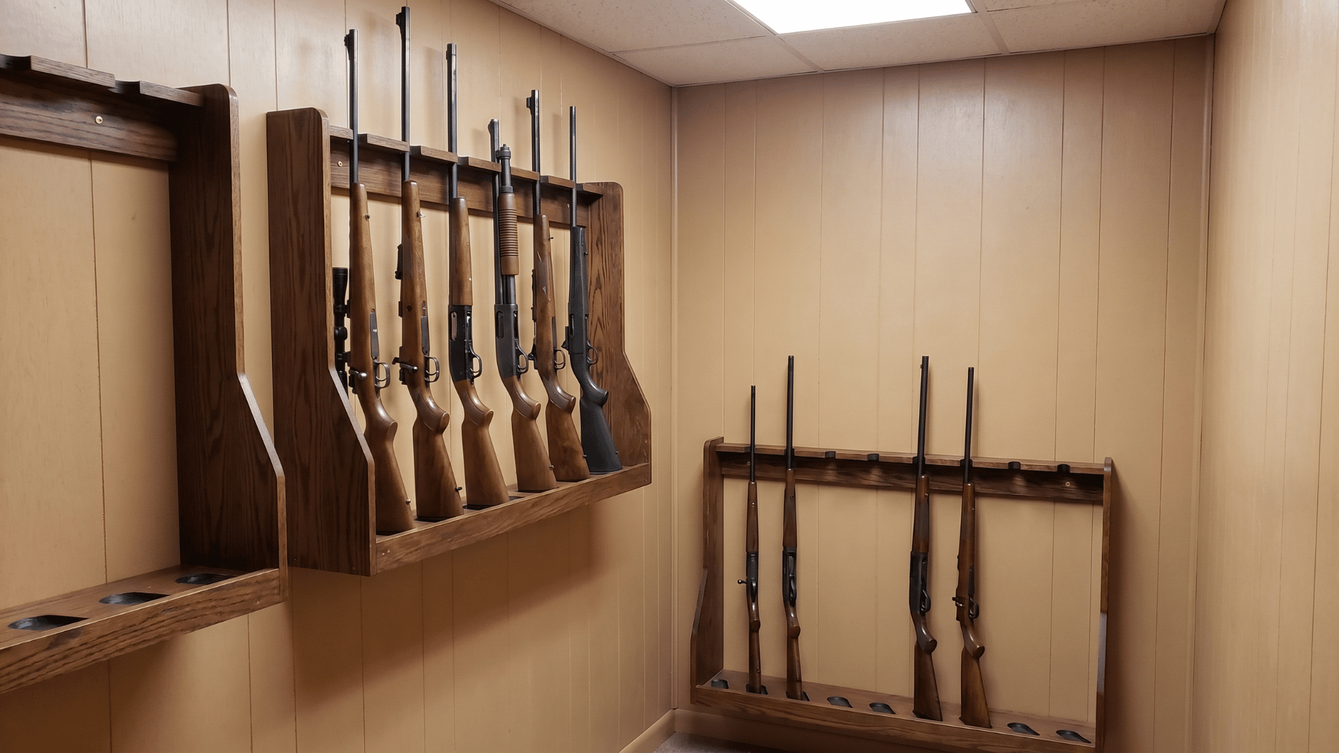 wall-mounted gun racks with rifles and shotguns neatly stored in a small room