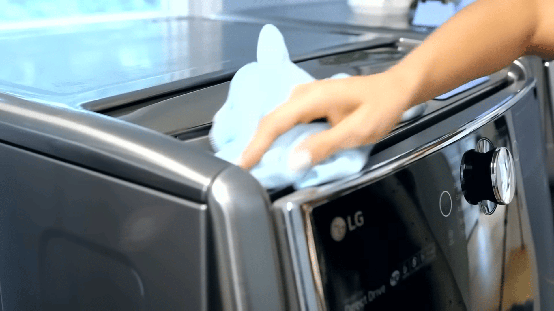Wiping down the outer console and top surface of a washing machine with a cloth