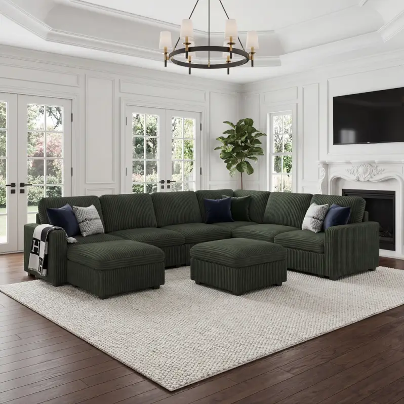 Dark green corduroy sectional sofa in elegant living room with large windows and chandelier